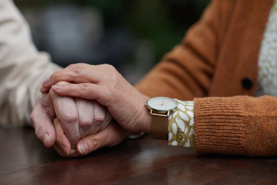 close up of senior couple holding hands