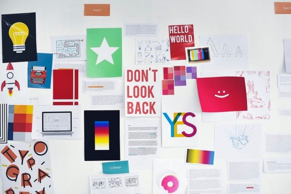 Different bits of paper, stickers, and happy words of encouragement cover a vision board.