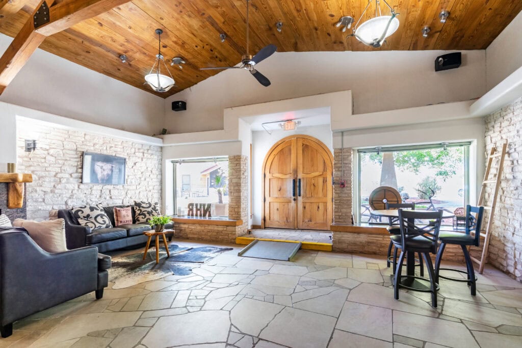 Lobby with leather sofas and arched wooden doors at New Hope Ranch