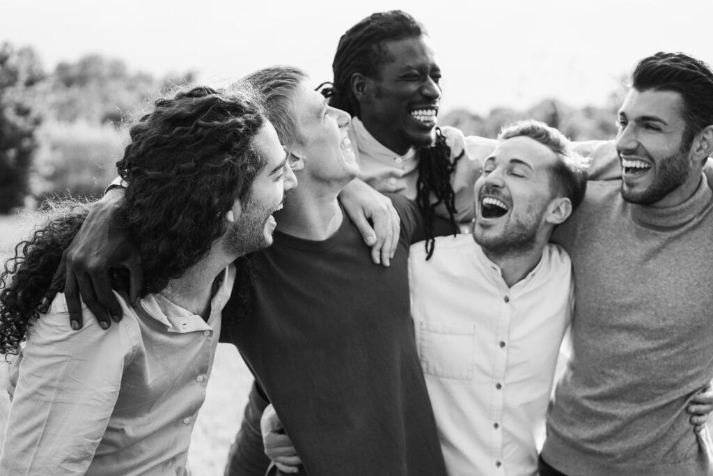 Group of men laughing and embracing outdoors